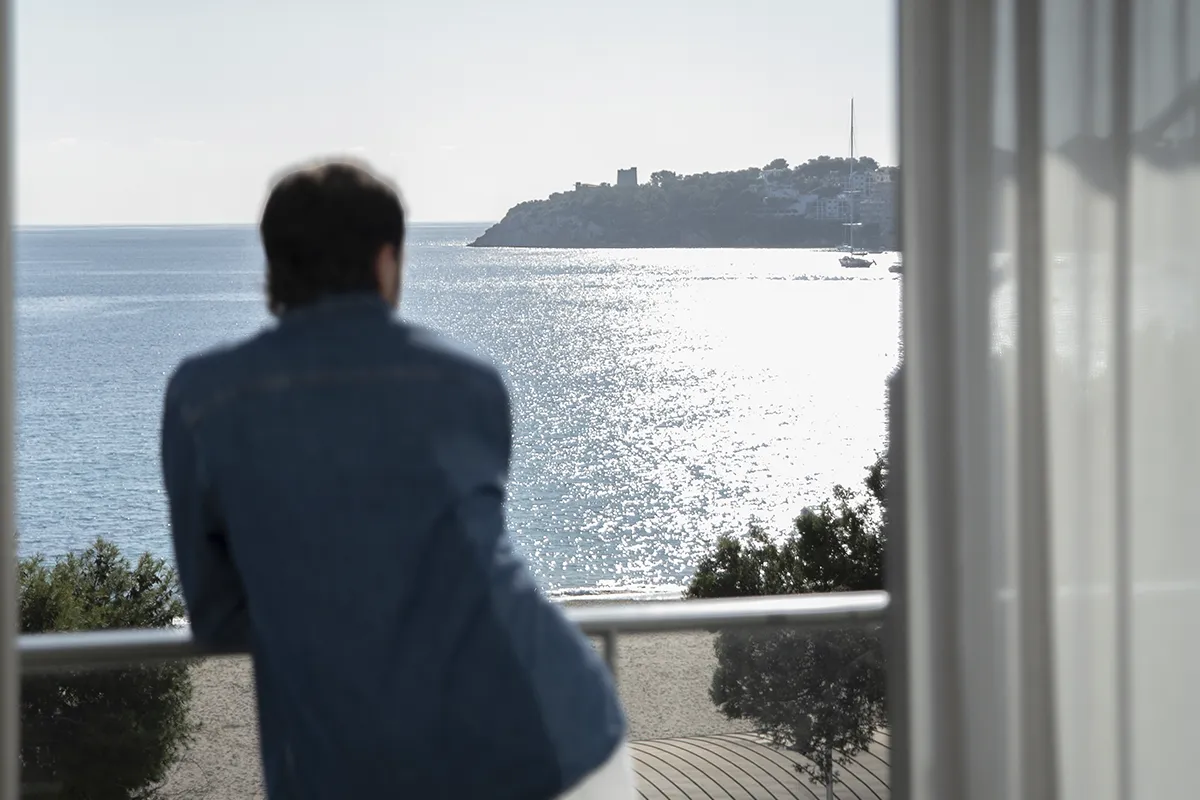Hombre contemplando las vistas desde habitación del Fergus Style Palmanova