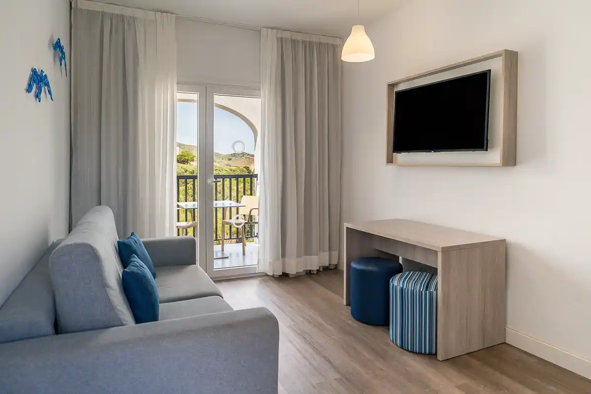 Sala de estar con tv y acceso a balcón del Fergus Carema Splash