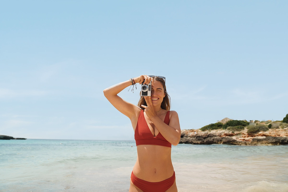 Chica junto al mar haciendo fotografía frente al hotel Fergus Style Carema Beach