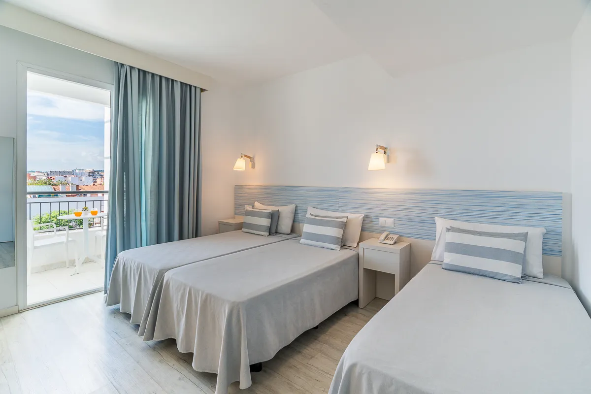 Tres camas individuales en la habitación Triple Deluxe con vista a la piscina en Fergus Club Pineda Splash