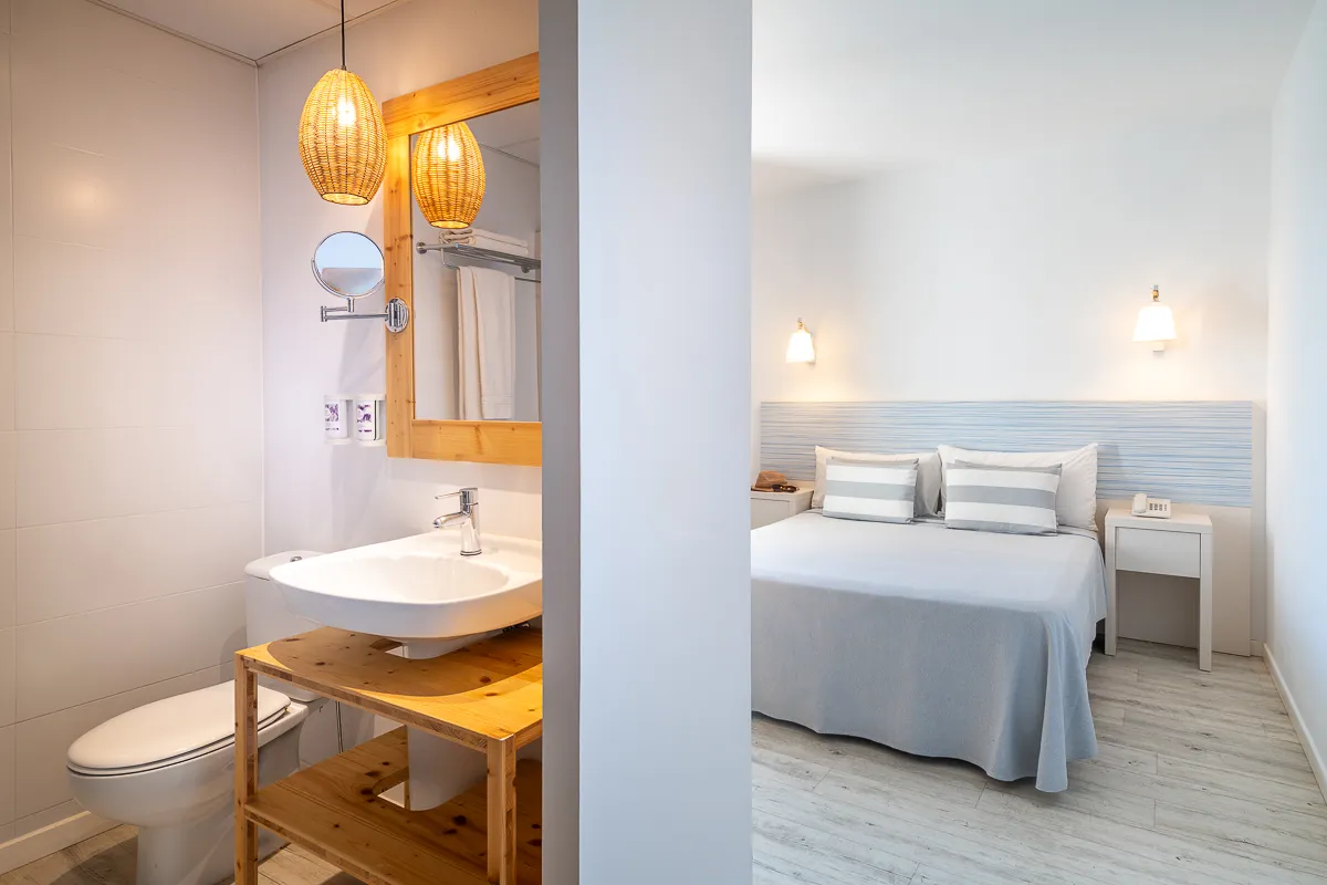 Vista parcial del baño y la habitación de la habitación doble Deluxe en Fergus Club Pineda Splash