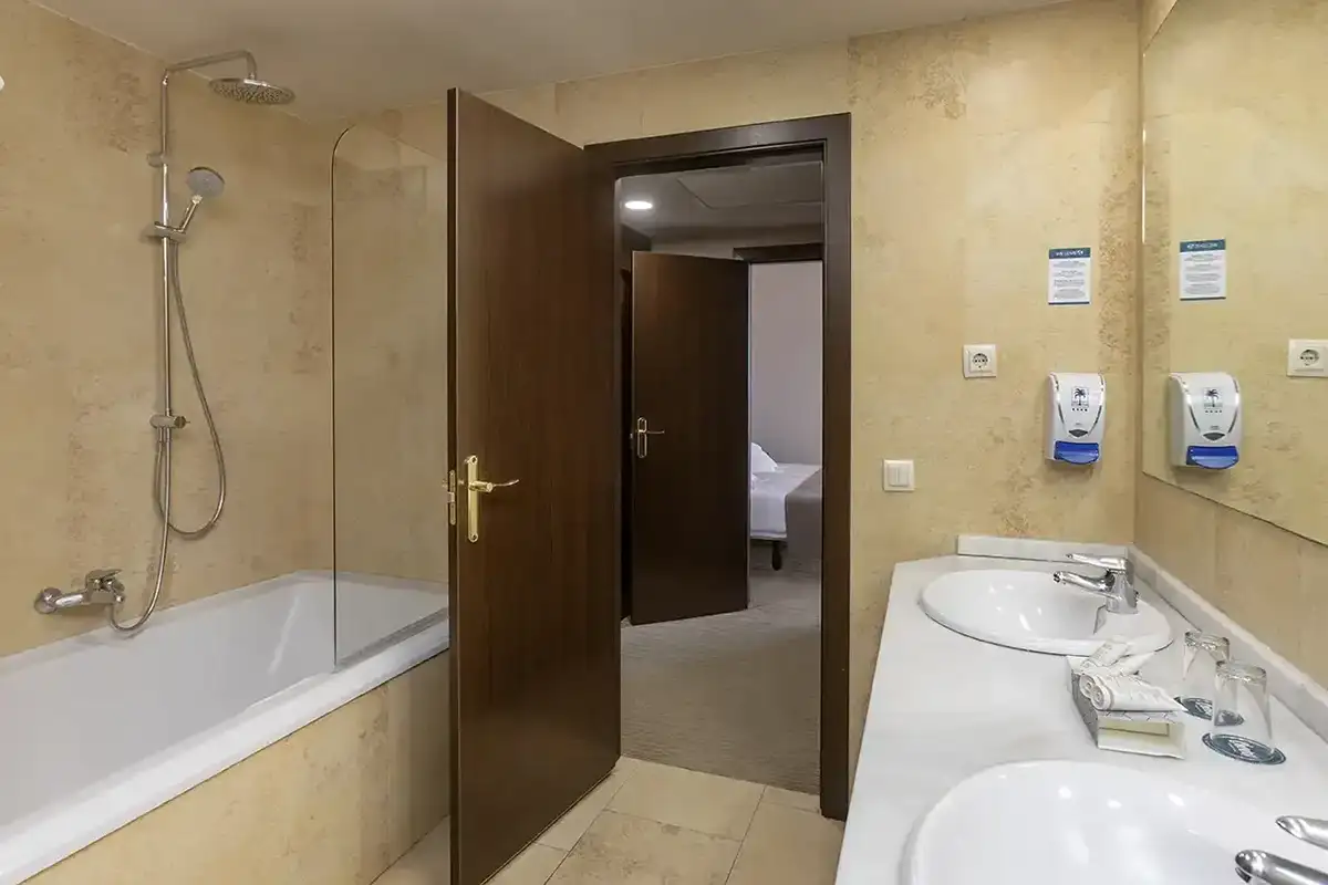Cuarto de baño funcional con bañera de la Junior Suite del hotel Las Palmeras Affiliated by Fergus Hotels