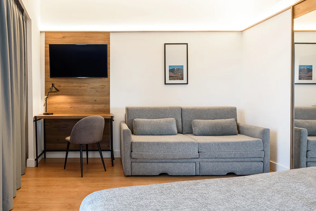 Escritorio, televisión y sofá en la junior Suite del Fergus Puerto de la Cruz