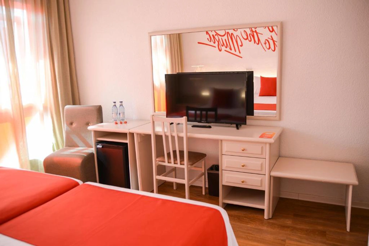 Zona de escritorio y televisión en la triple deluxe Lloret Vibe affiliated by Fergus Hotels