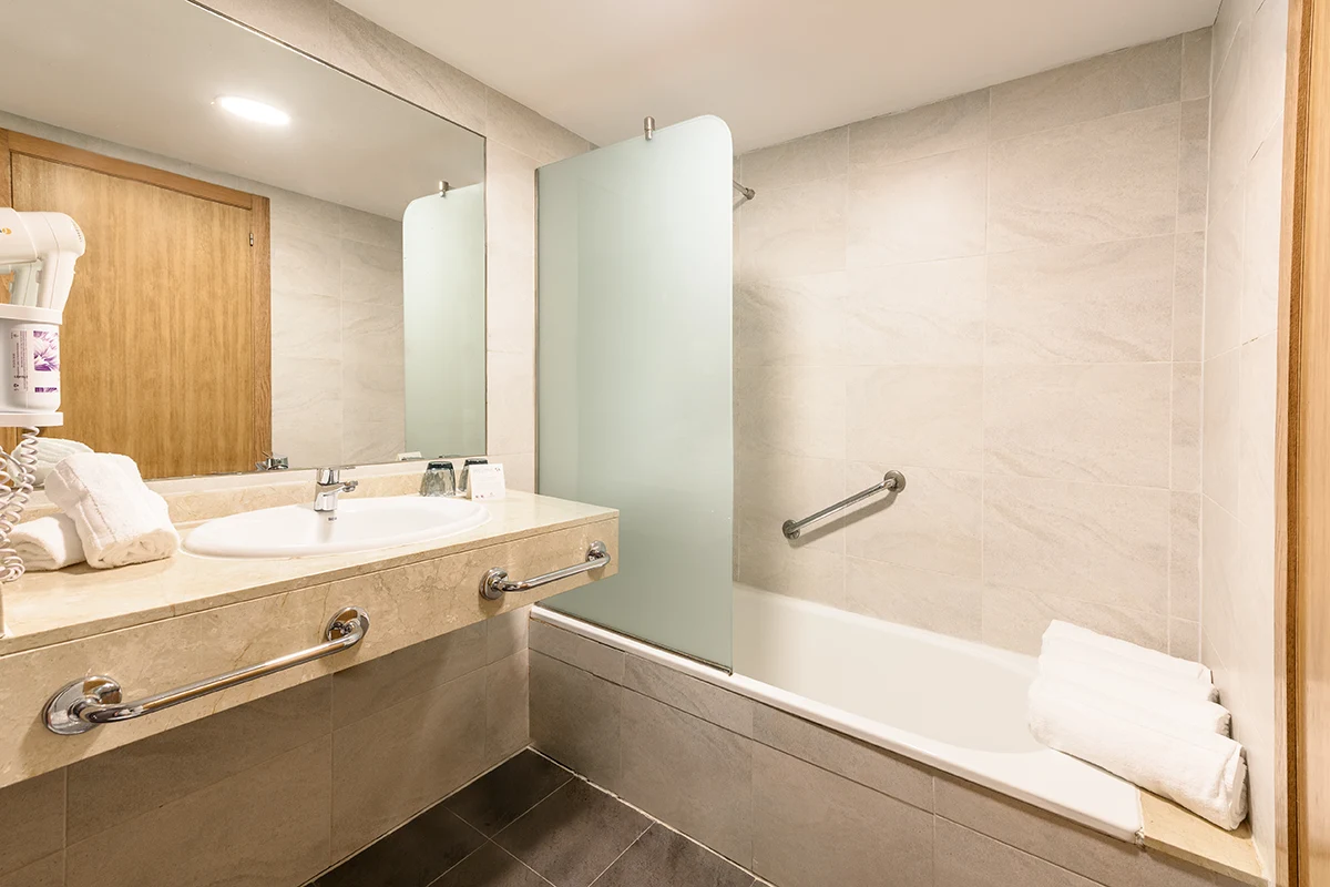Bathroom with bathtub Bathroom with bathtub, large washbasin and mirror in the Family Room Fergus Club Palmanova Park Hotel