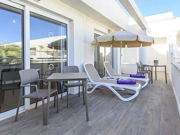 Private terrace with jacuzzi Private terrace equipped with comfortable chairs, tables, loungers and a jacuzzi, in the exclusive Magnus Suite at Fergus Palmanova Park