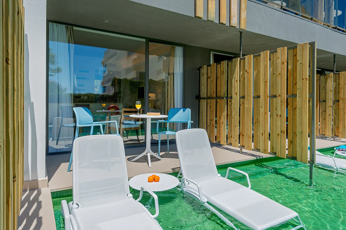 Terraza con zona de solárium y hamacas en habitación swim-up del Fergus Style Palmanova