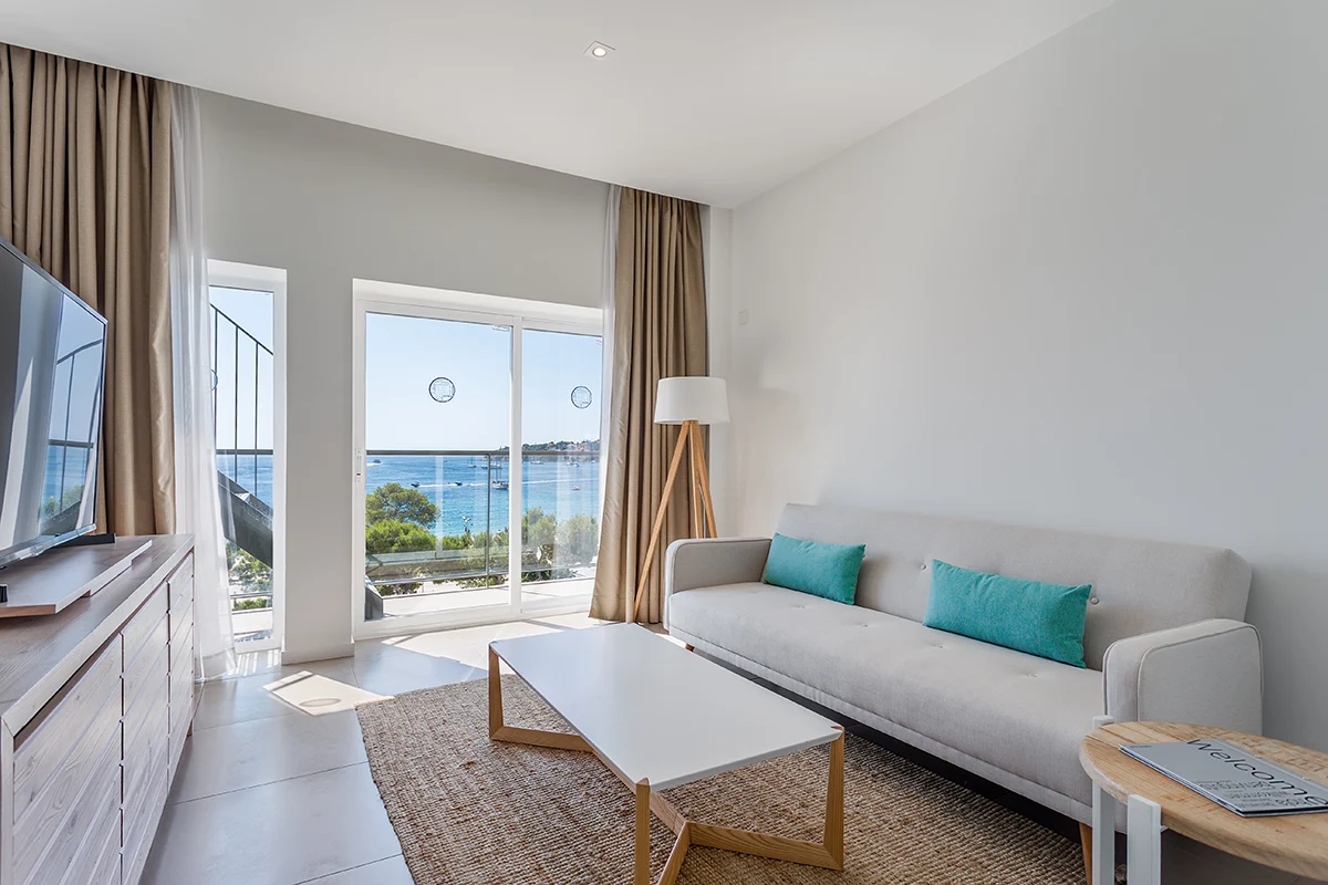 Amplio y confortable salón con televisión y acceso a terraza de la Suite del Fergus Style Palmanova