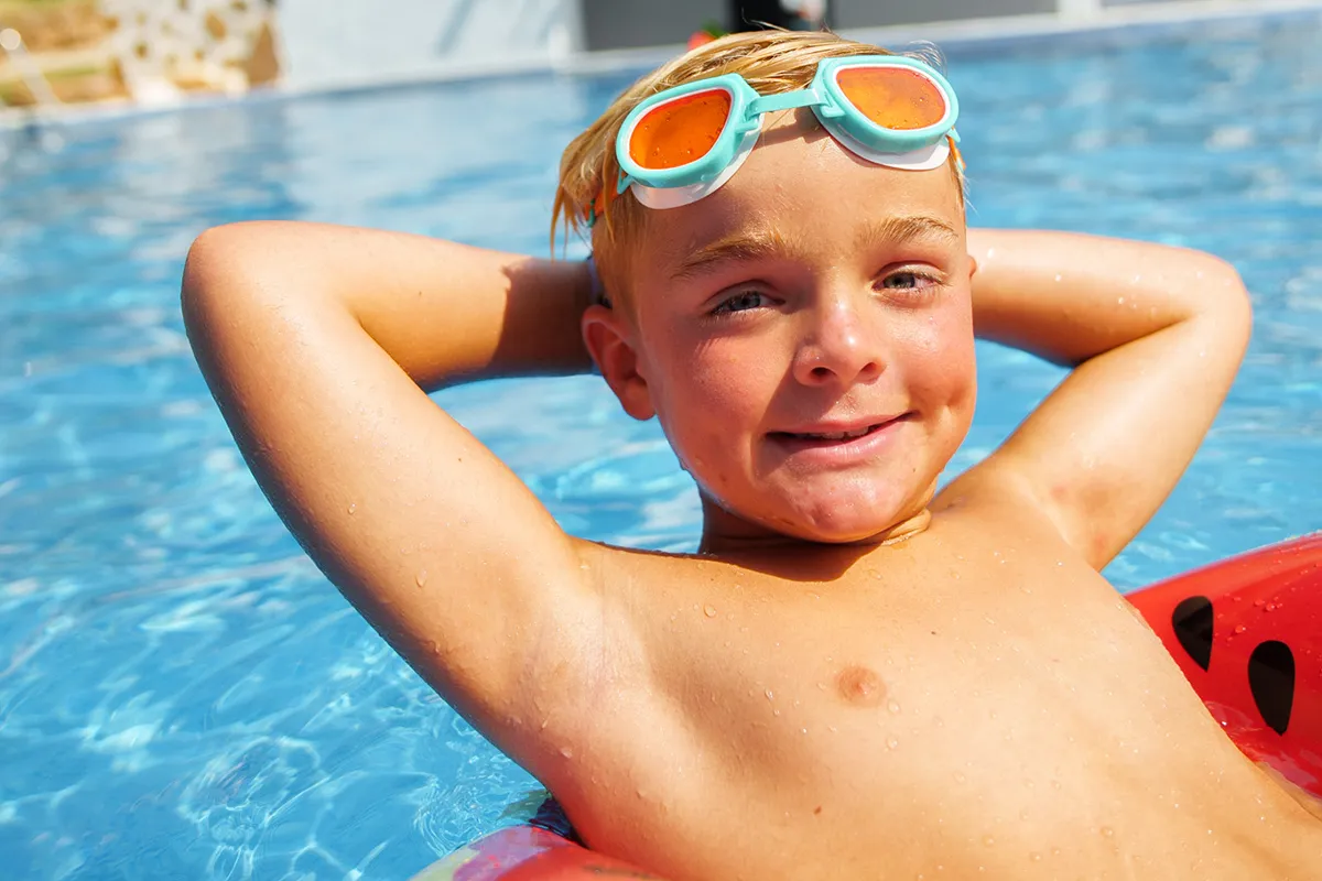 Child on an inflatable mattress in a pool at Fergus Hotels