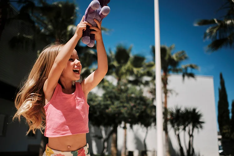 Girl playing with a stuffed toy at Fergus Hotels
